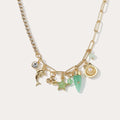 Gold necklace with various charms on a light background