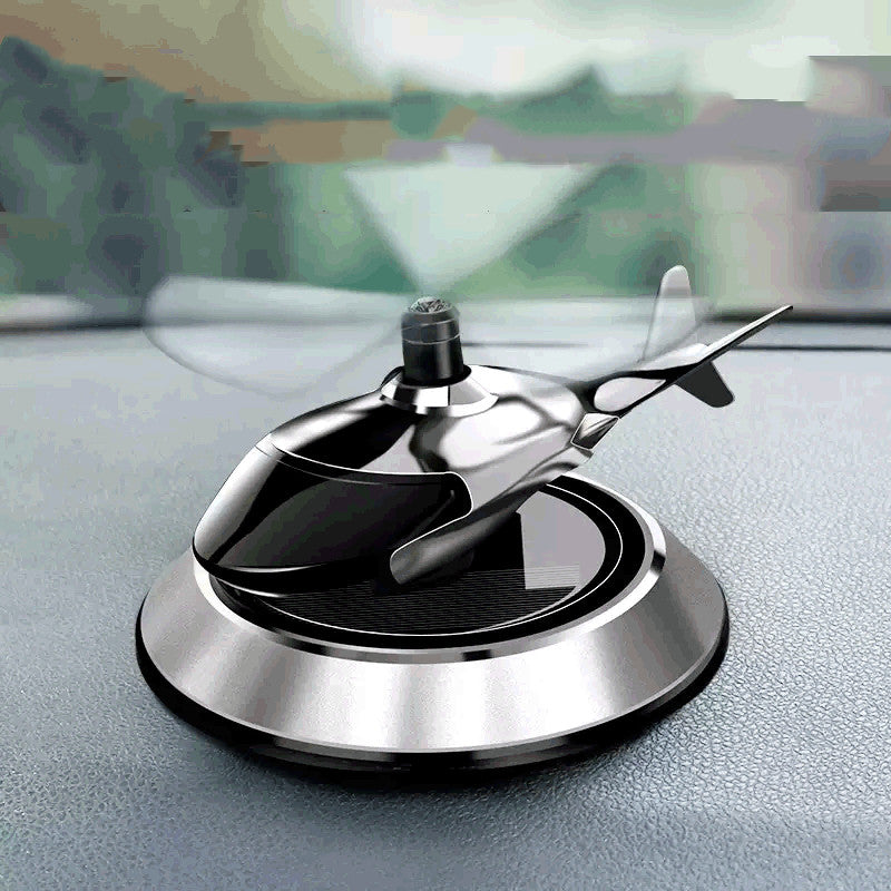 Decorative car emblem with airplane design on a car dashboard