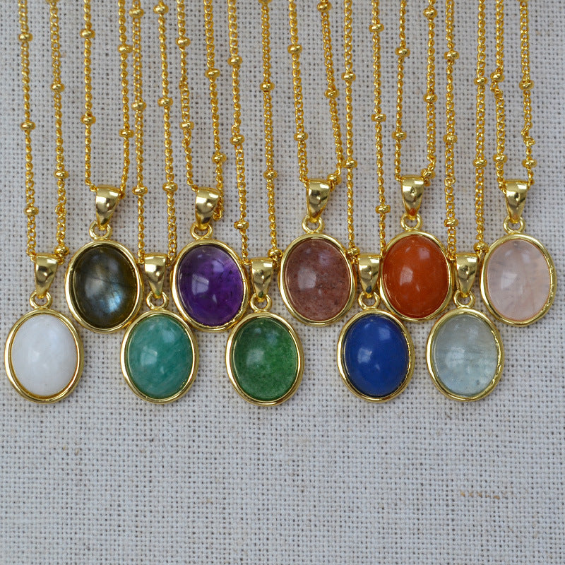 Gold necklaces with colorful gemstone pendants on a textured fabric background