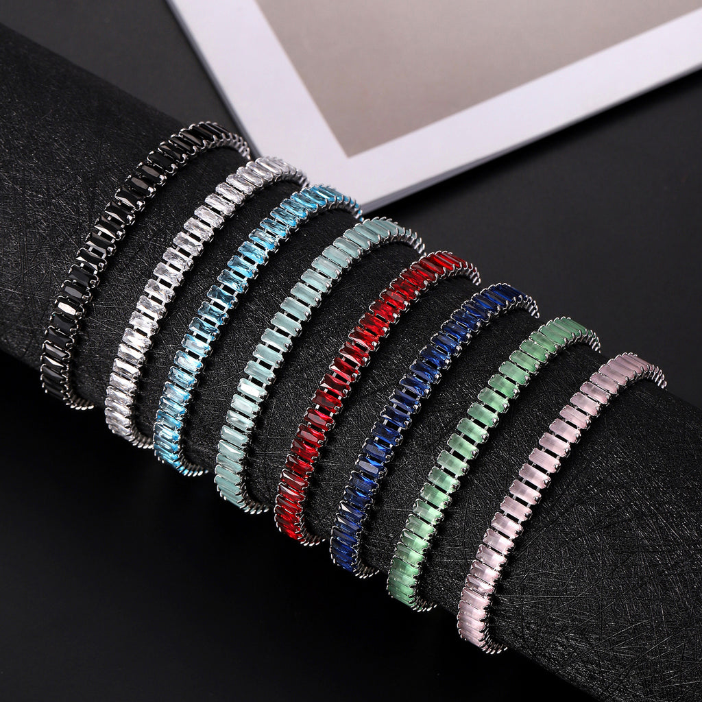 Set of colorful bracelets on a black surface with a white frame in the background