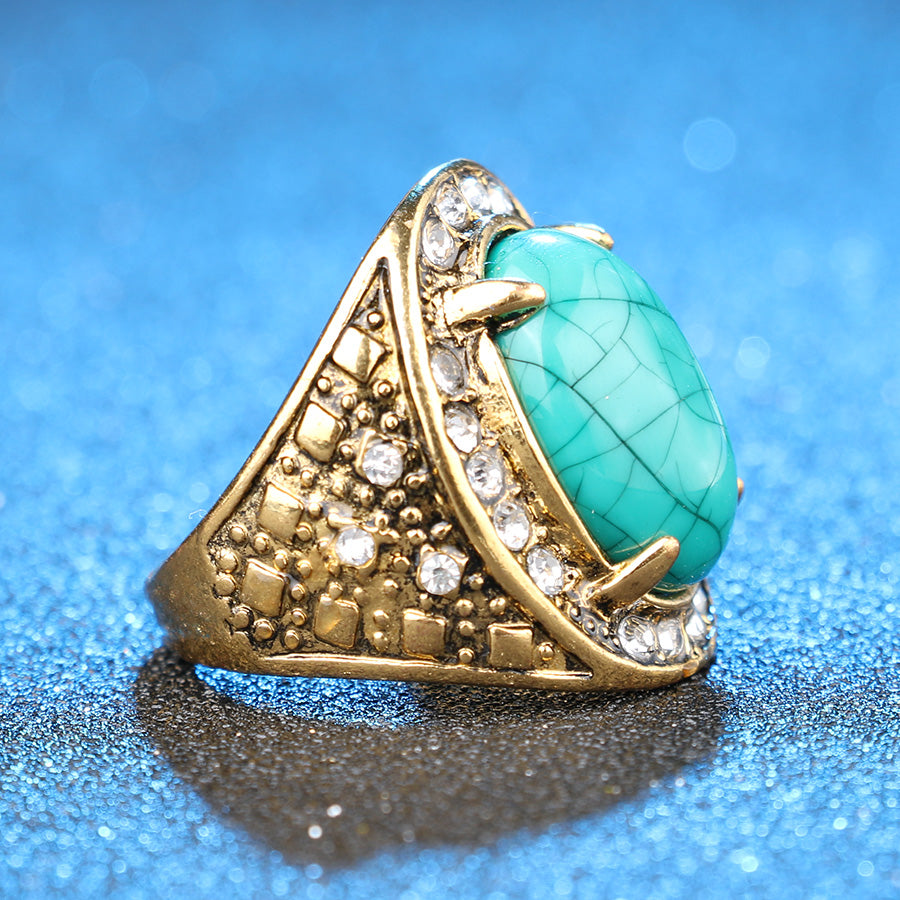 Gold ring with a turquoise stone on a blue background