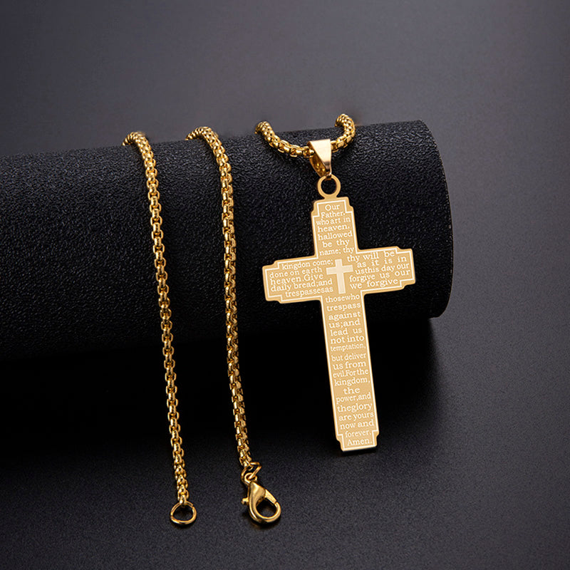 Gold cross pendant necklace on a black cylindrical stand with a dark background