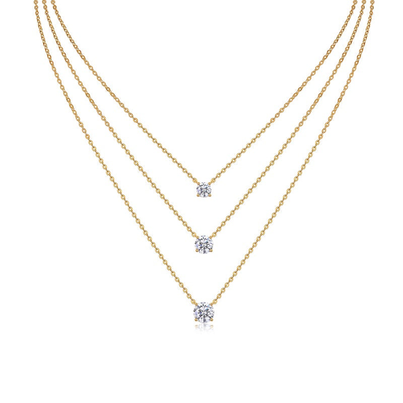 Three gold necklaces with diamond pendants on a white background
