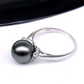 Silver ring with a large black pearl and small diamond on a white background