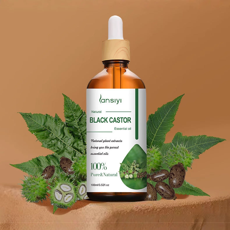 Bottle of lansiyi Black Castor essential oil with leaves and seeds on a brown background