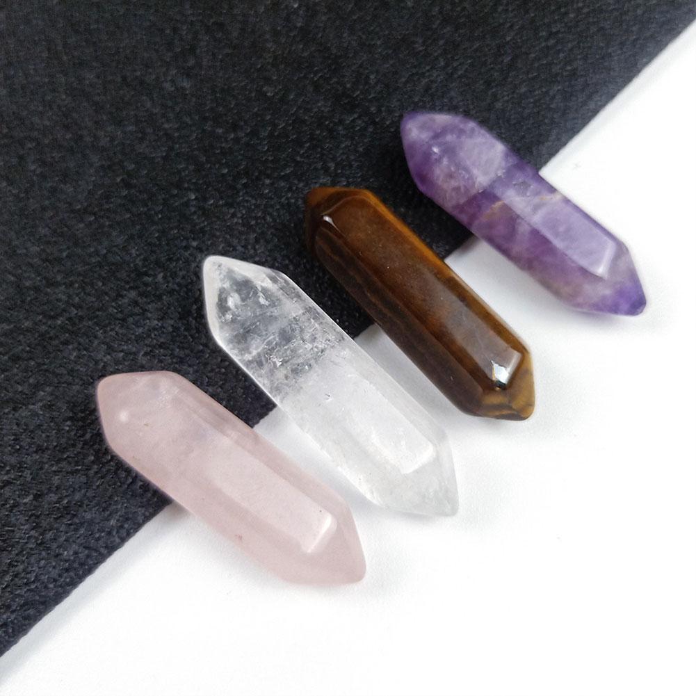 Four crystal points in different colors on a dark fabric background
