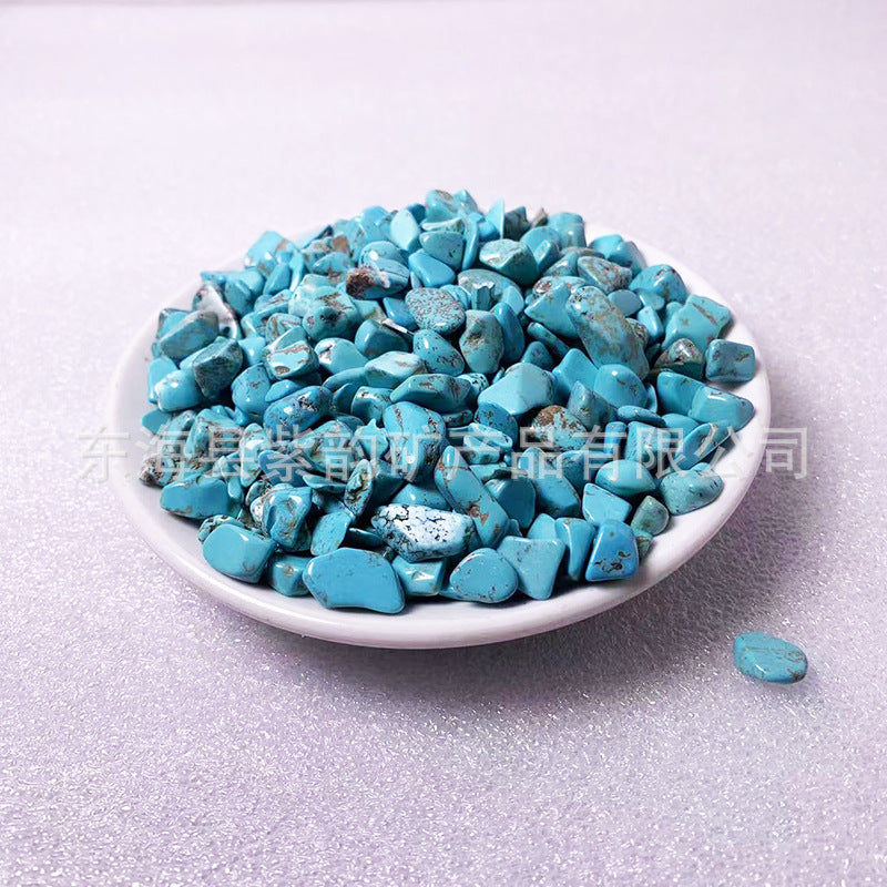 Turquoise stones on a white plate with a light gray background