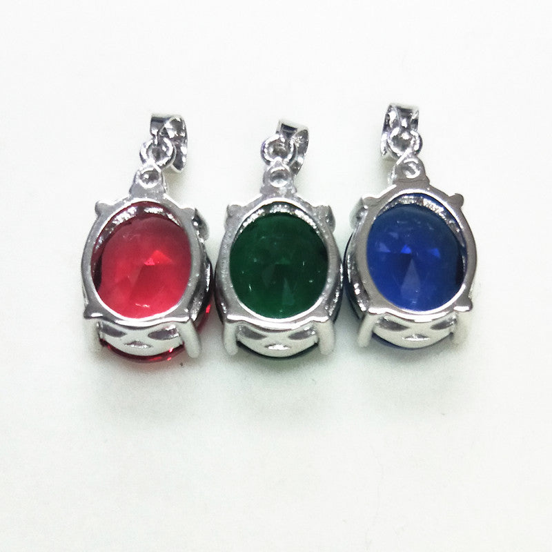 Three silver pendants with red, green, and blue gemstones on a white background
