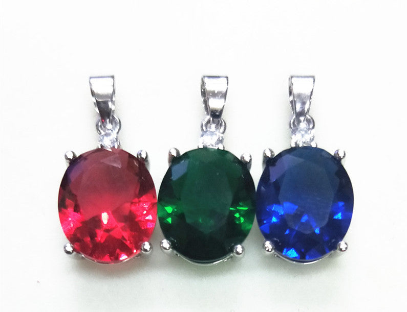 Three gemstone pendants in red, green, and blue on a white background