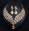 Gold and crystal necklace and earrings on a black background