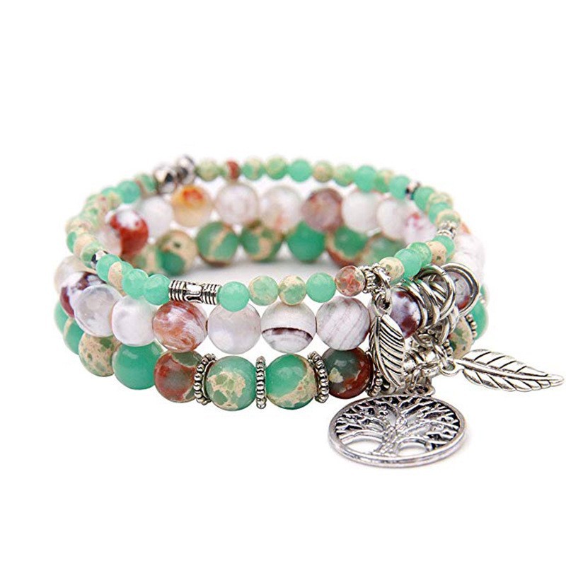 Multicolored beaded bracelet with a silver tree of life charm on a white background