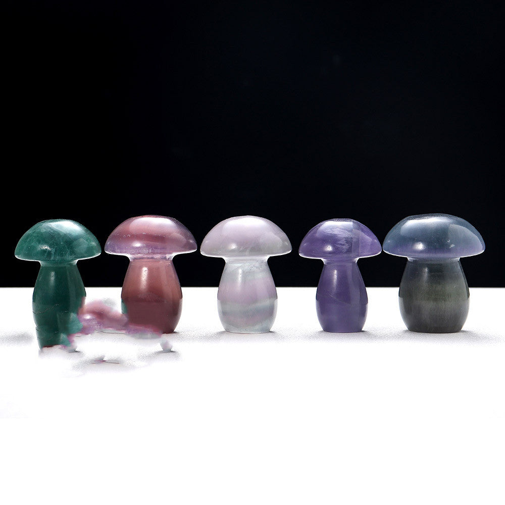 Set of colorful glass mushroom-shaped objects on a white surface with a black background