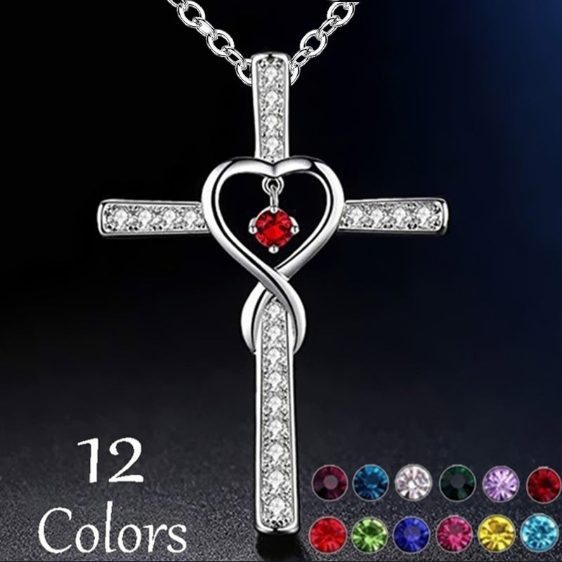 Silver cross necklace with heart and red gemstone on a dark background, featuring 12 color options.