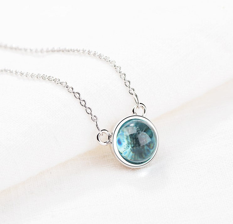 Necklace with a blue gemstone pendant on a white background