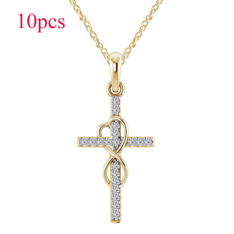 Gold cross pendant necklace with heart design on a white background