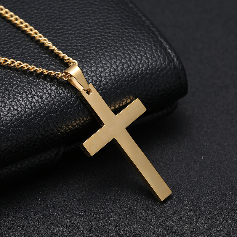 Gold cross pendant on a chain against a black textured background