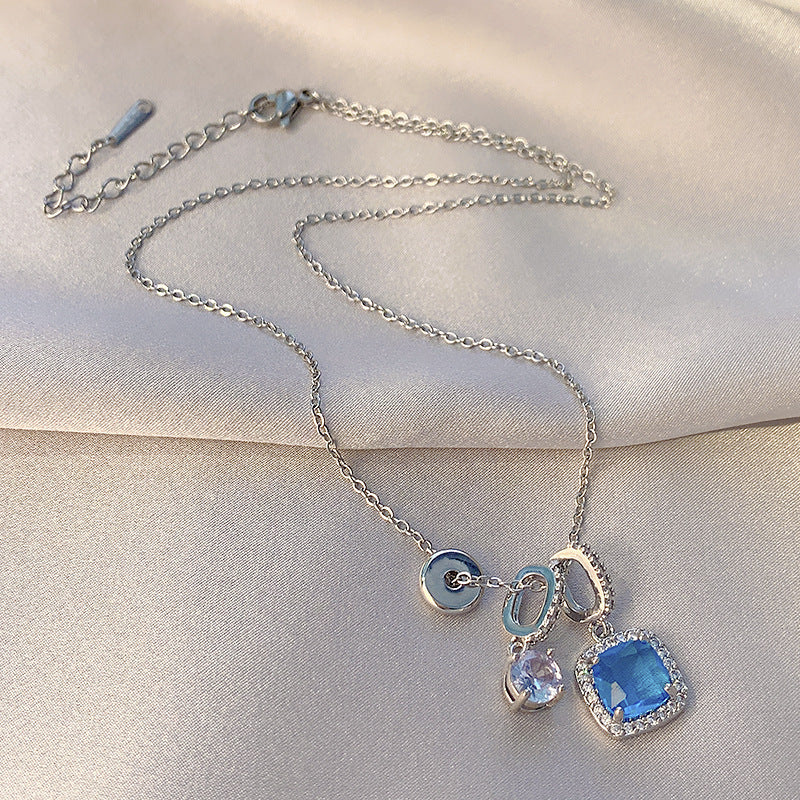 Silver necklace with blue gemstone pendants on a light fabric background