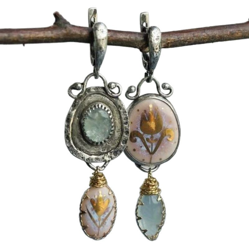 Pair of earrings with intricate designs on a white background