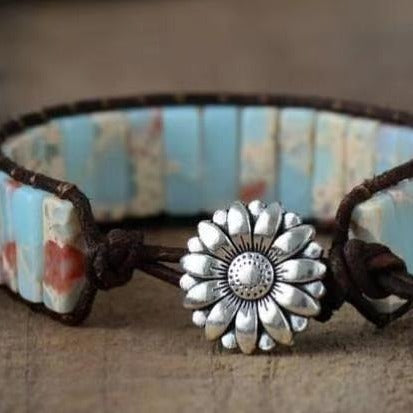 Bracelet with a sunflower-shaped clasp on a textured surface