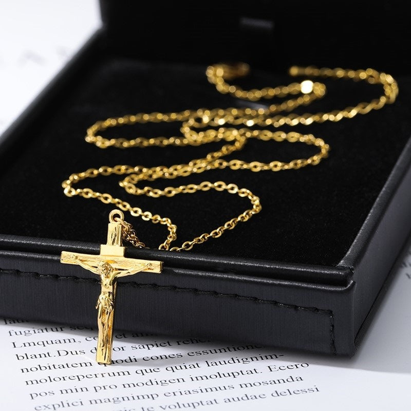 Gold crucifix necklace on a black box with text underneath