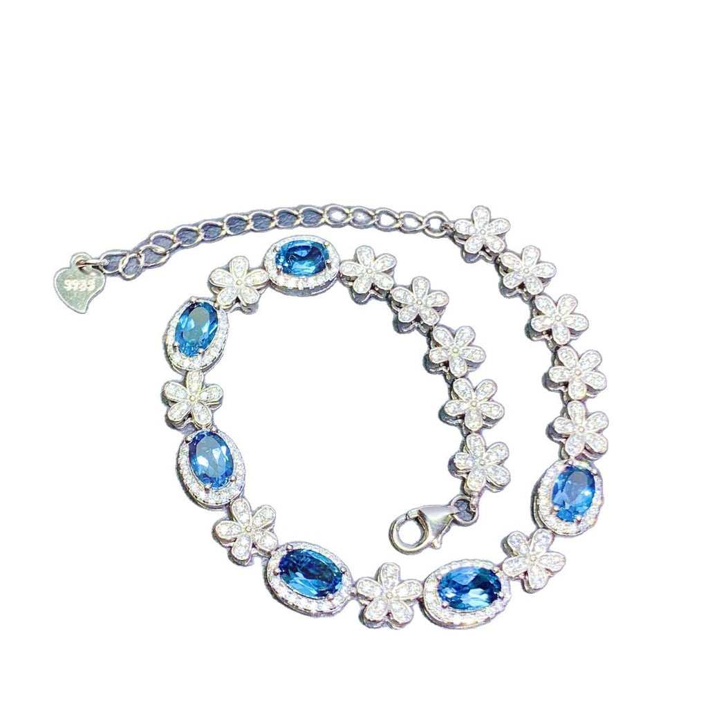 Bracelet with blue gemstones and floral designs on a white background