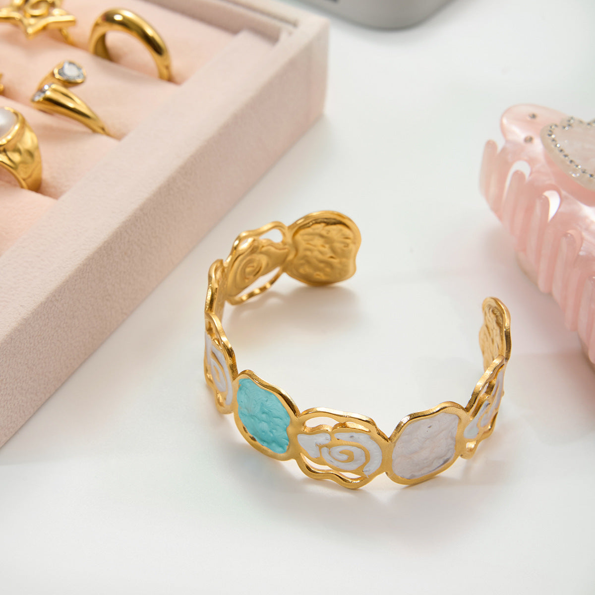 Gold bracelet with decorative elements on a light surface