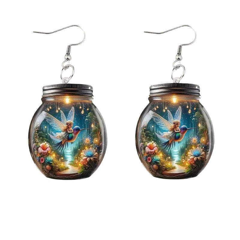 Mason jar-shaped earrings with fairy design on a white background