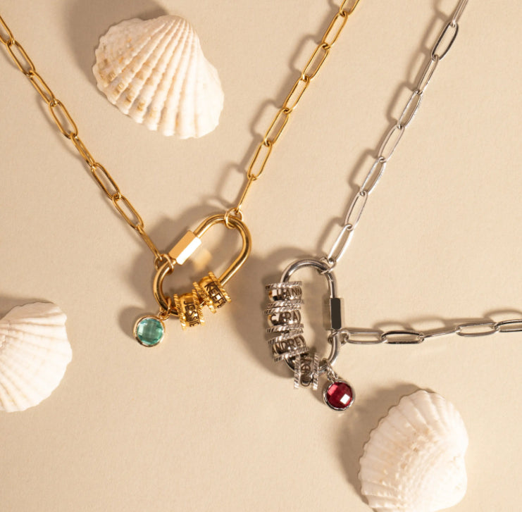 Two necklaces with lock pendants on a beige background with shells.