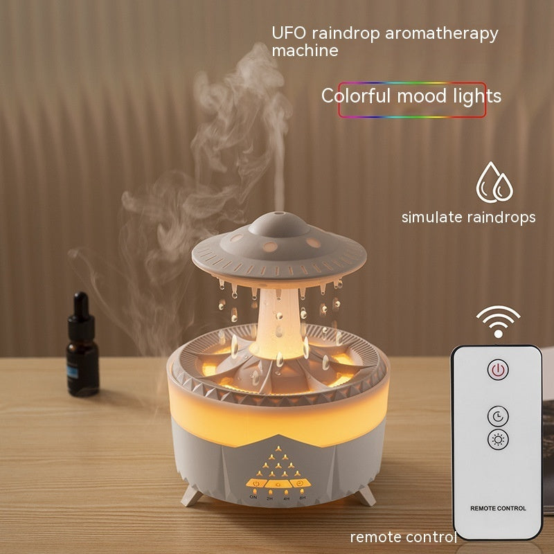 UFO raindrop aromatherapy machine with remote control on a wooden surface