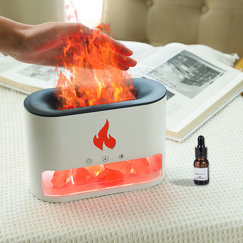 Small flame simulator on a table with a bottle of essential oil nearby