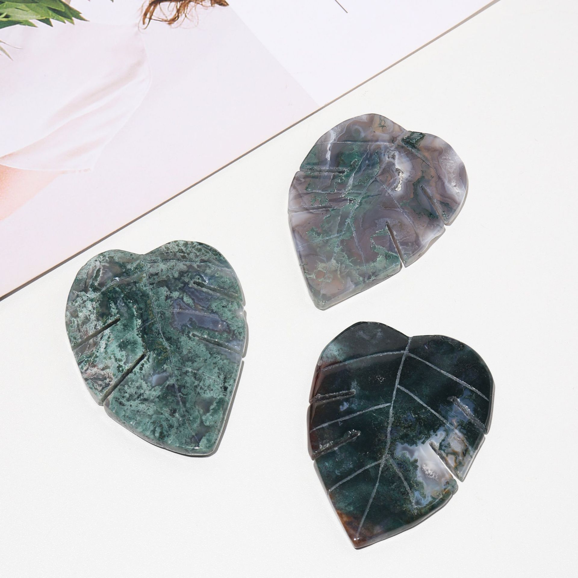 Three heart-shaped green stones on a light surface