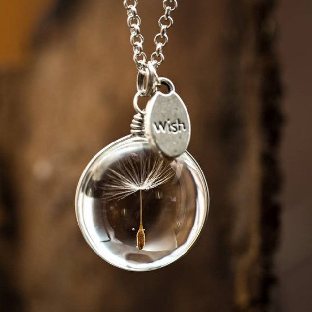 Silver necklace with a clear pendant containing a dandelion seed, labeled 'Wish'.