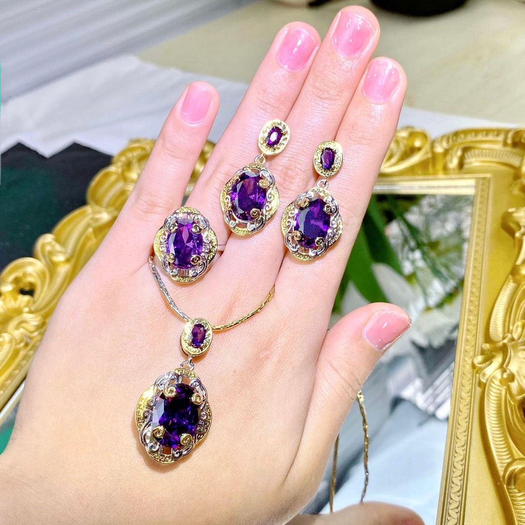 Purple gemstone earrings on a hand with a decorative background
