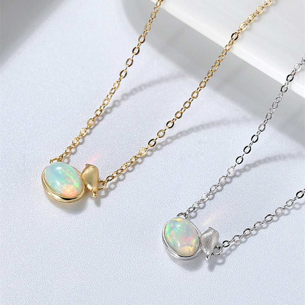 Two opal necklaces, one gold and one silver, on a light gray background.