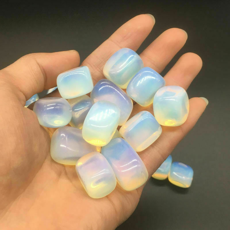 Hand holding a collection of iridescent stones against a dark background