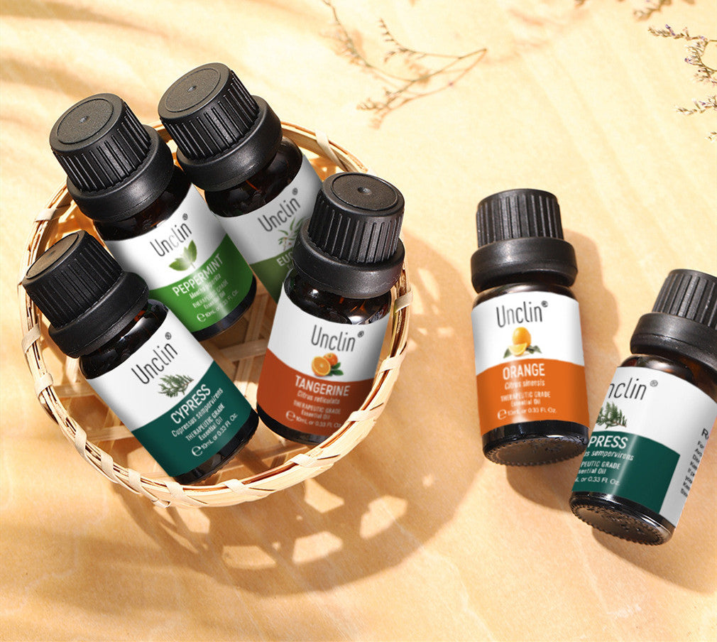 Collection of Unclin essential oil bottles with labels on a beige background
