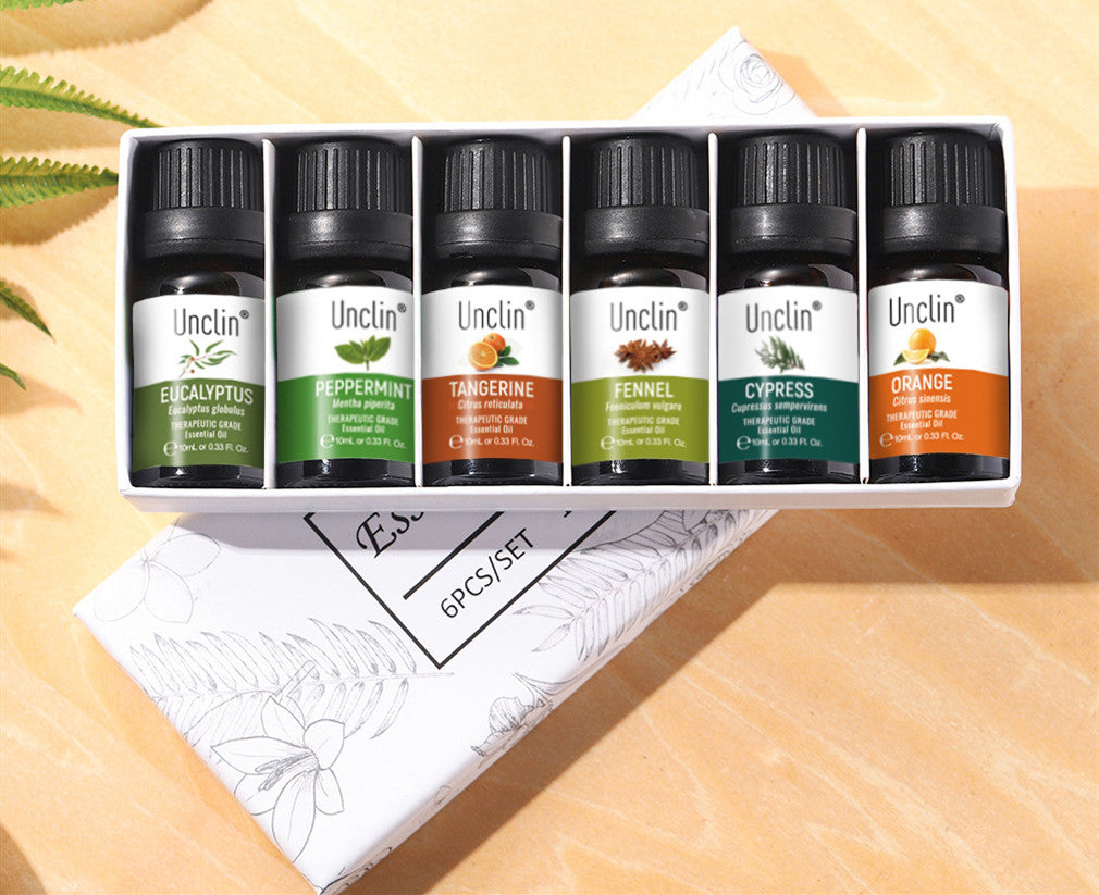 Set of Unclin essential oil bottles in a box on a wooden surface