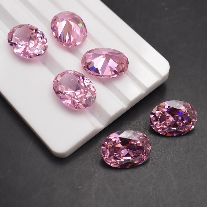 Pink gemstones on a white tray with a dark background