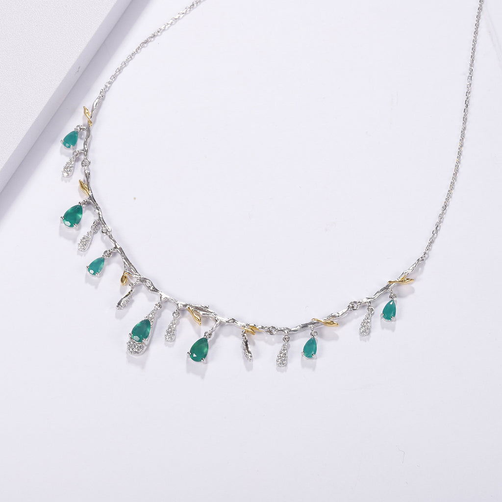 Necklace with green gemstones and gold accents on a white background