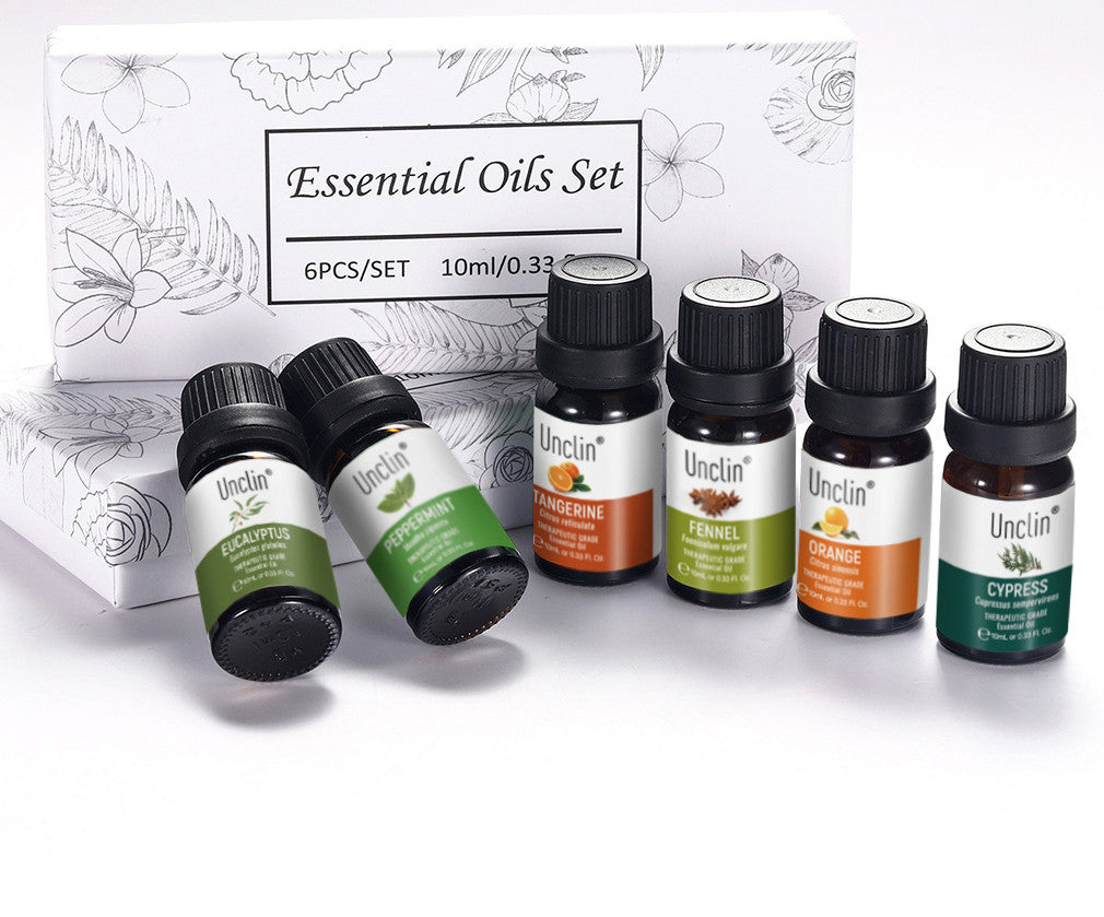 Set of six essential oil bottles with labels in front of a branded box.