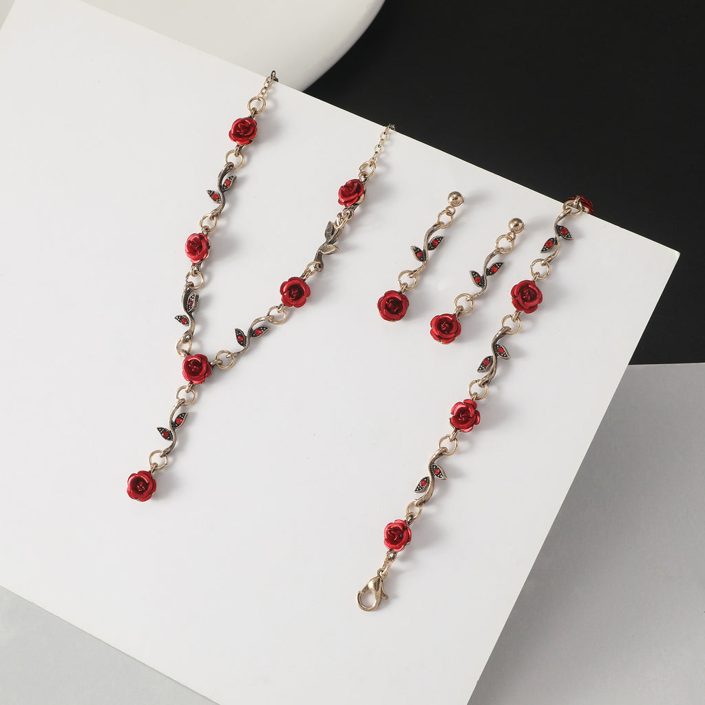 Jewelry set with red floral design on a white surface
