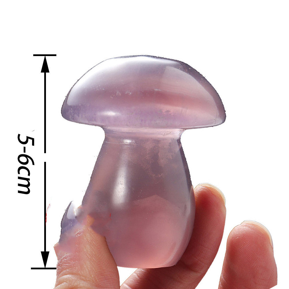 Transparent pink mushroom-shaped object held by a hand with measurement details.