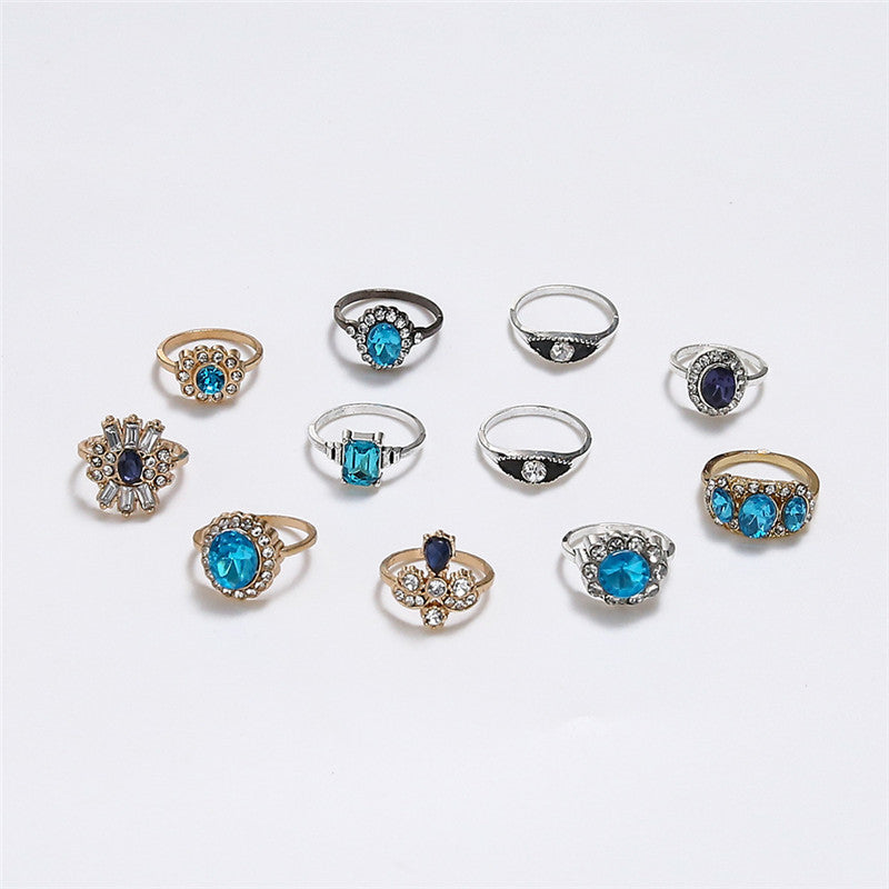 Collection of various rings with blue gemstones on a light gray background
