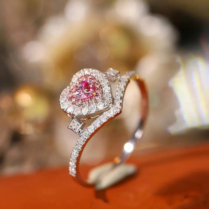 Diamond ring with a pink gemstone on an orange surface