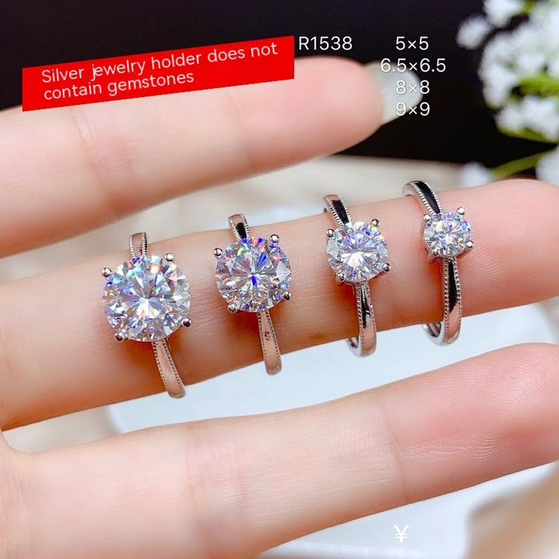 Silver jewelry holder with diamond rings on a hand against a blurred floral background