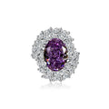 Purple gemstone ring with diamond halo on a white background