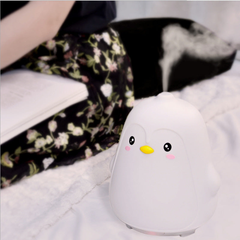 Cute penguin-shaped night light on a soft surface with a blurred background