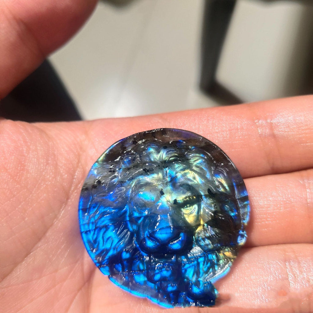Blue glass gemstone held in a hand with a blurred background