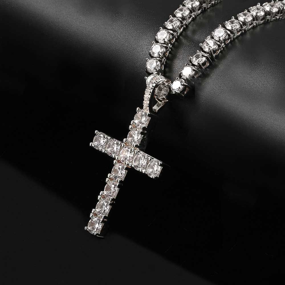 Diamond-studded cross pendant on a chain against a dark background
