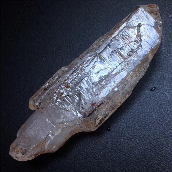 Crystal-like object with engraved patterns on a dark surface